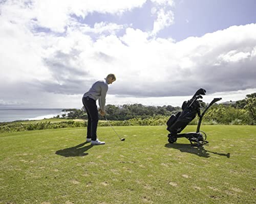 Golfer preparing to swing on a sunny day with golf bag nearby.