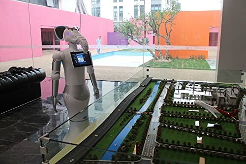 Robot with elephant head in a modern building next to a model display