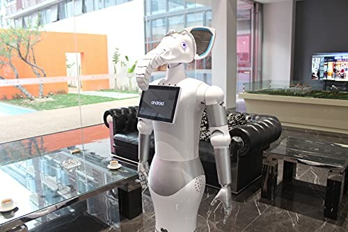 Robot with an elephant head and a screen in a modern room